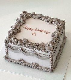 a birthday cake that is sitting on top of a white table with the words happy birthday written on it