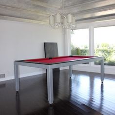 a pool table with a red cloth on it in front of a chandelier