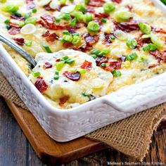 a casserole dish with bacon, cheese and green onions