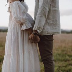 a man and woman holding hands in a field