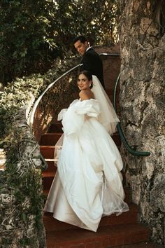 the bride and groom are walking down the stairs