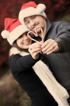 a man and woman holding candy canes in their hands