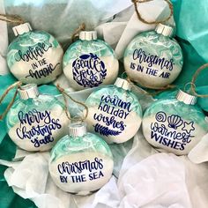 six glass ornaments that say christmas is in the air and have blue writing on them