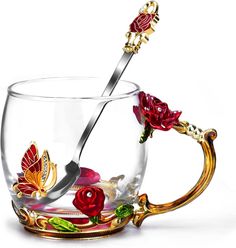 a glass cup with a spoon in it and some flowers on the inside is gold