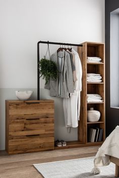 an open wardrobe with clothes hanging on it