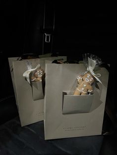 two brown paper bags with white polka dots on them, one has a cookie in it