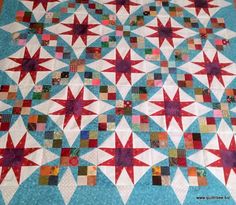 a quilted table topper with many different colored stars on it