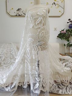 a white dress on a mannequin in a room with flowers and other decorations