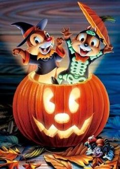 an animated halloween scene with two cats in a pumpkin