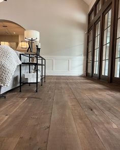 a living room with wood floors and large windows