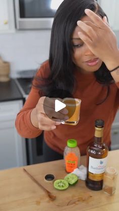 a woman sitting at a kitchen counter holding her head in her hands and looking down