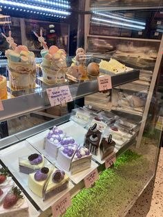 a display case filled with lots of different types of cakes and desserts on top of it