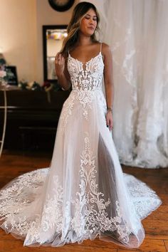 a woman in a white wedding dress standing on a wooden floor