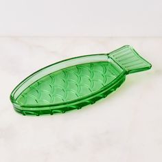 a green glass serving dish on a marble surface