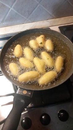 some food is cooking in a frying pan on the burner top stovetop