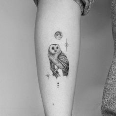 a black and white photo of an owl on the left arm with stars around it