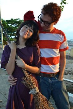 a man standing next to a woman holding a knife in her hand while wearing a striped shirt