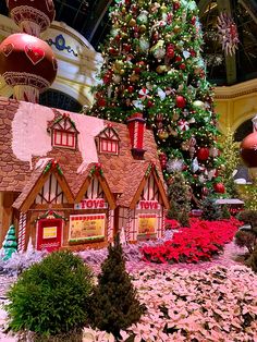 the christmas tree is decorated with red and green decorations, including gingerbread houses that look like santa's house