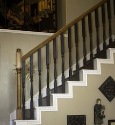 there is a clock that is on the wall next to the stair case in this house