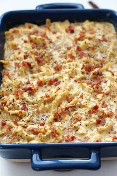 a blue casserole dish filled with pasta and cheese