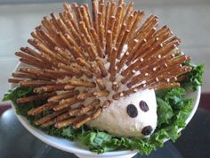 a hedgehog made out of bread sticks and lettuce in a white bowl