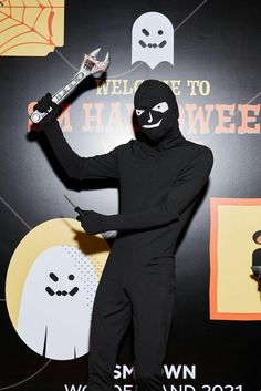 a man in a black costume holding a skateboard