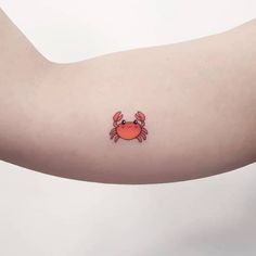 a crab tattoo on the left arm and right arm with an orange crab drawn on it