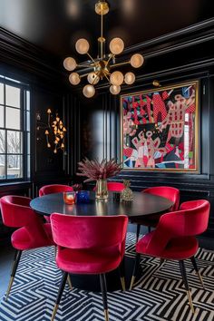 an elegant dining room with black walls and red chairs, art work on the wall