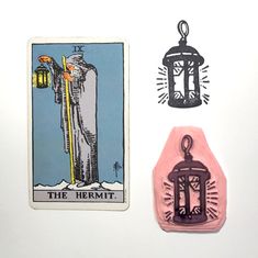 the hermit tarot card is next to a rubber stamp with an image of a man holding a lantern