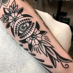 a black and white tattoo with an eye in the center on someone's arm