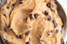 a bowl filled with chocolate chip cookie dough on top of a white cloth covered table