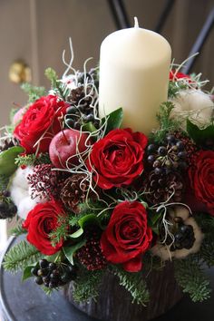 a candle is sitting on top of a flower arrangement