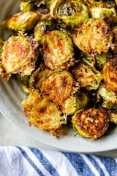 cooked brussel sprouts in a white bowl on a blue and white towel