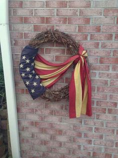 a patriotic wreath hanging on the side of a brick wall