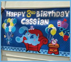 a birthday banner with an image of a cartoon character sitting in a chair and balloons