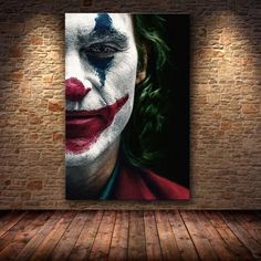 the joker movie poster hanging on a brick wall in an empty room with wooden floors