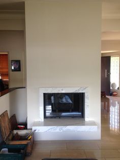 an empty living room with a fireplace in the center and several boxes on the floor