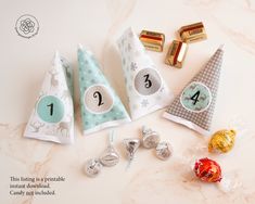 four party hats with numbers on them sitting next to candy bar wrappers and candies