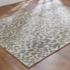 an animal print rug on the floor in a room with hardwood floors and hard wood floors