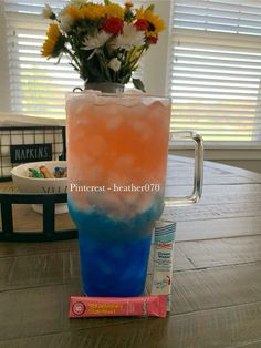 a tall glass filled with liquid sitting on top of a table next to a tube of toothpaste