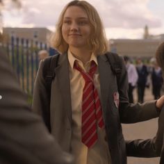 a woman in a suit and tie standing next to other people