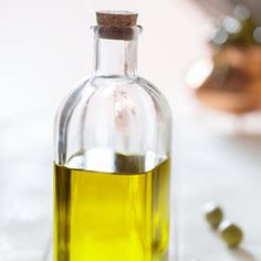 a bottle filled with olive oil sitting on top of a table