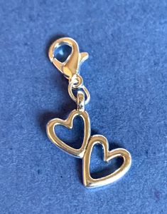 two heart shaped charms on a blue surface