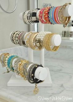 there are many different bracelets on the rack in this bathroom sink mirror display case