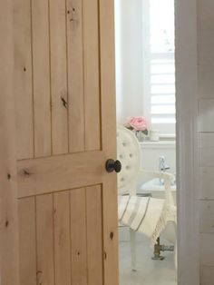 an open wooden door leading to a bathroom