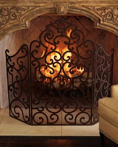 an ornate fireplace screen with flames burning in it