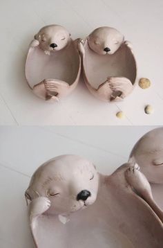 two ceramic sea animals sitting on top of each other next to one another with their eyes closed