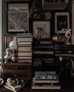 there are many books on the table with pictures above them and other items around it