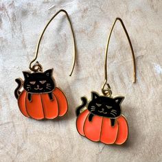 Embrace the Halloween spirit with these delightful Black Cat Orange Pumpkin Earrings! These festive earrings feature an adorable black cat peeking out from inside a bright orange pumpkin, perfectly capturing the playful and spooky essence of the season. These earrings are the perfect accessory to add a touch of Halloween fun to your outfit, whether you're dressing up for a party or adding a festive flair to your everyday look. Get ready to charm everyone with these purrfectly spooky earrings thi Black Cat Ears Earrings For Halloween, Black Cat Design Earrings For Halloween, Black Halloween Jewelry With Cat Ears, Halloween Cat Ears Earrings For Pierced Ears, Halloween Black Cat Design Jewelry, Halloween Cat Ears Earrings, Halloween Cat Design Earrings With Cat Ears, Black Cat Jewelry, Cat Themed Gifts