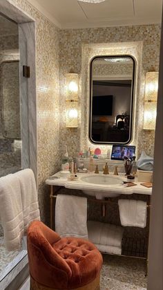 a bath room with a sink a mirror and a chair in it's corner